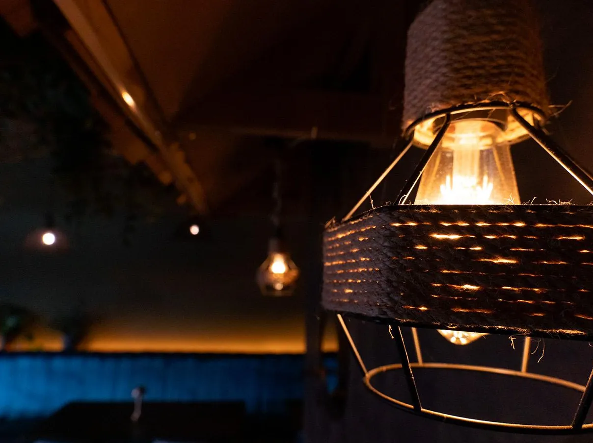 A rope lampshade glowing over the banquette