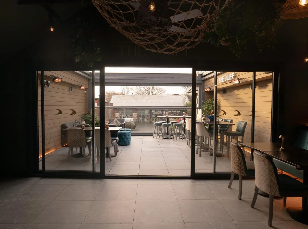 The room at night with the glass doors open to the rooftop